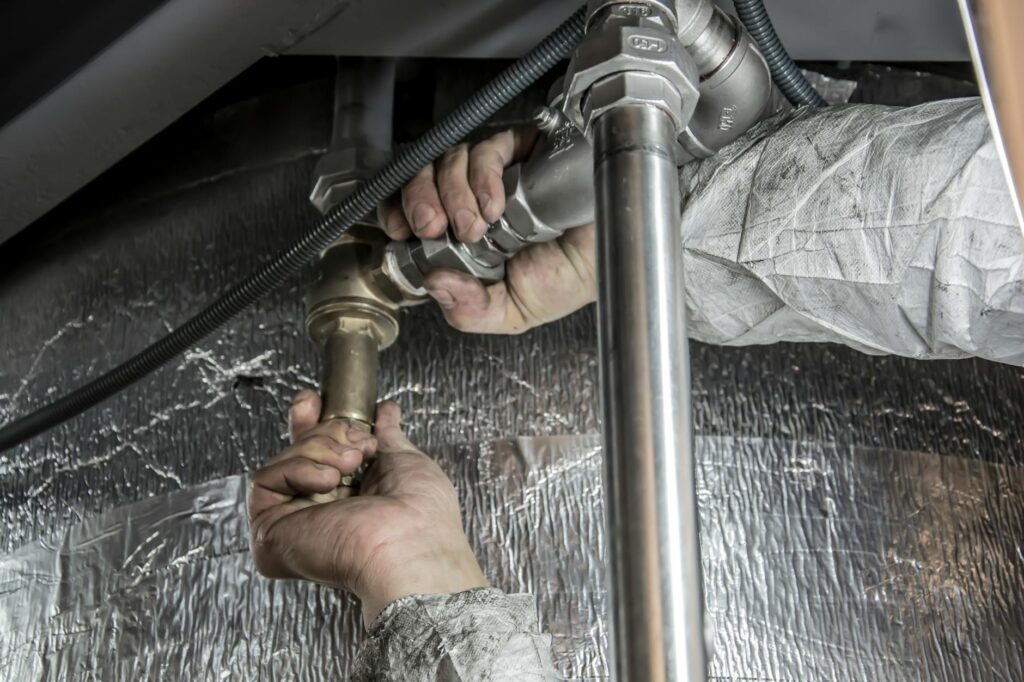 Tarif d'un plombier en intervention — plombier travaillant sur des tuyaux le week-end