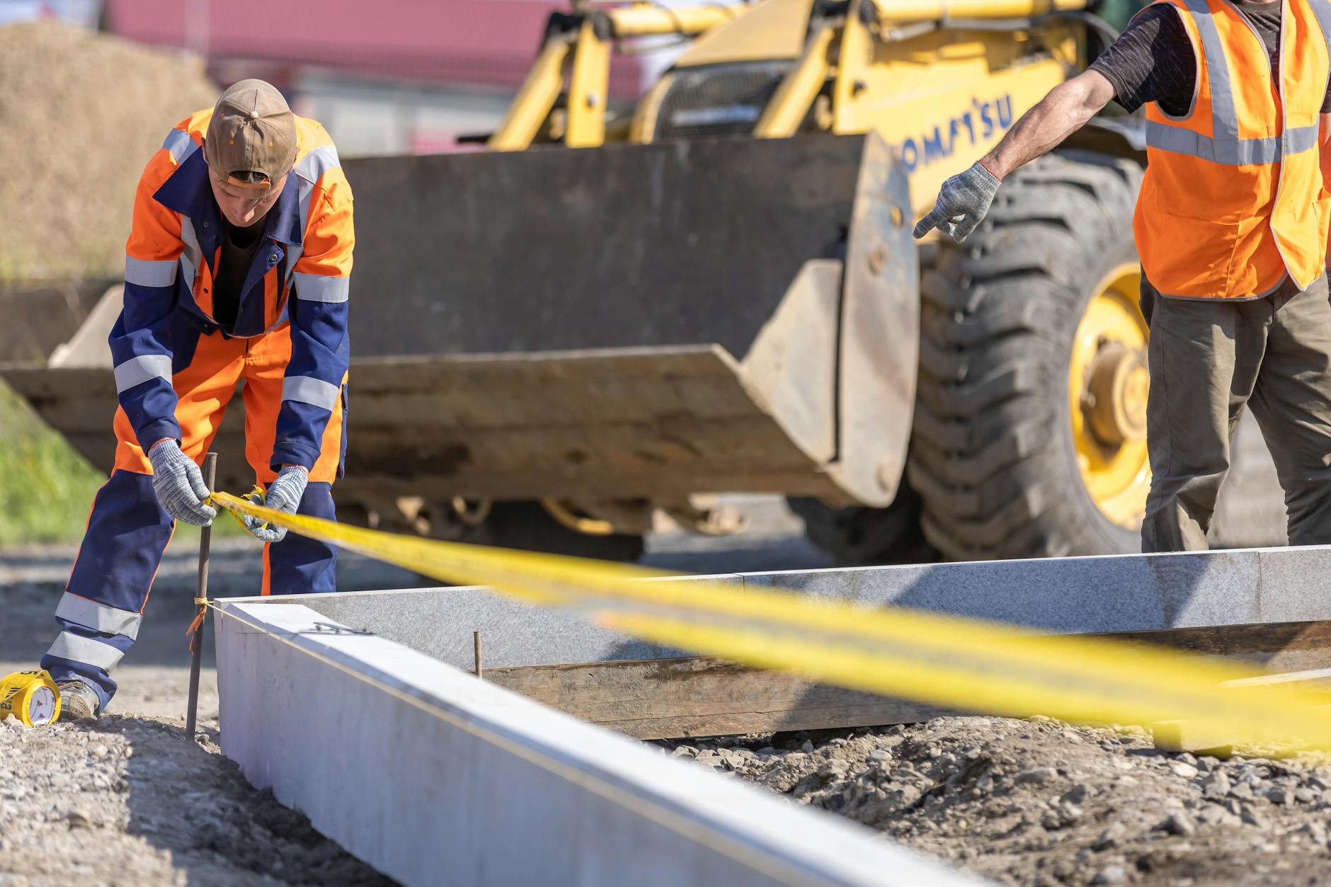 Mètre linéaire et mètre carré dans le bâtiment : bien distinguer les deux unités de mesure — mètre ruban sur chantier de construction